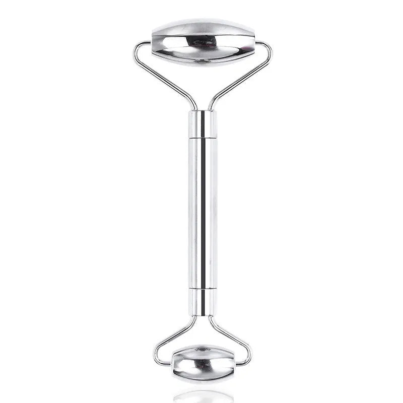 Stainless steel facial massage roller and heart-shaped gua sha plate set on a white background.