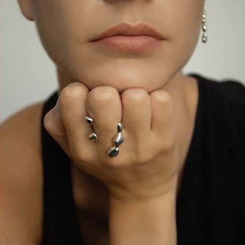 Gold and silver brass opening ring with sphere circle design on a woman's hand.