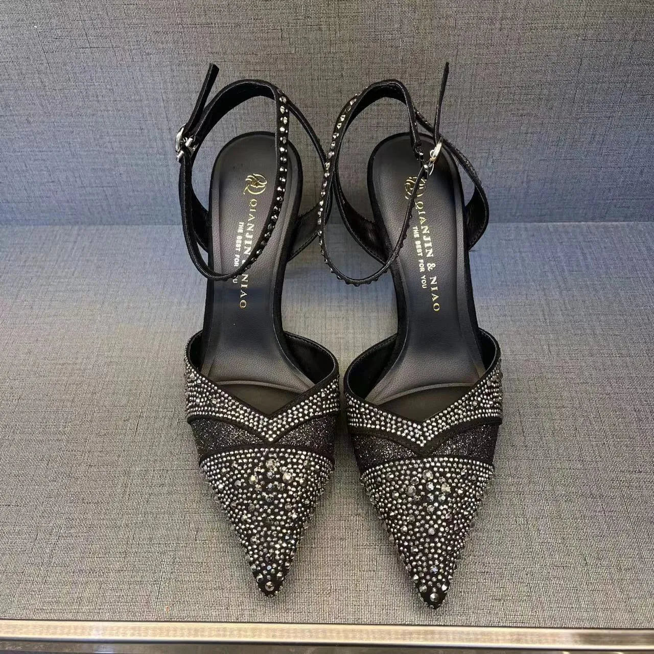 Women's black hollow stiletto heel pumps with a red sole and pointed toe.