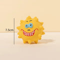 Set of four coloured latex squeaky dog balls with cute face designs on blue green red yellow backgrounds