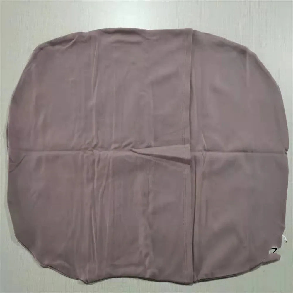 Beige portable baby nest crib cot for newborns on a neutral background.