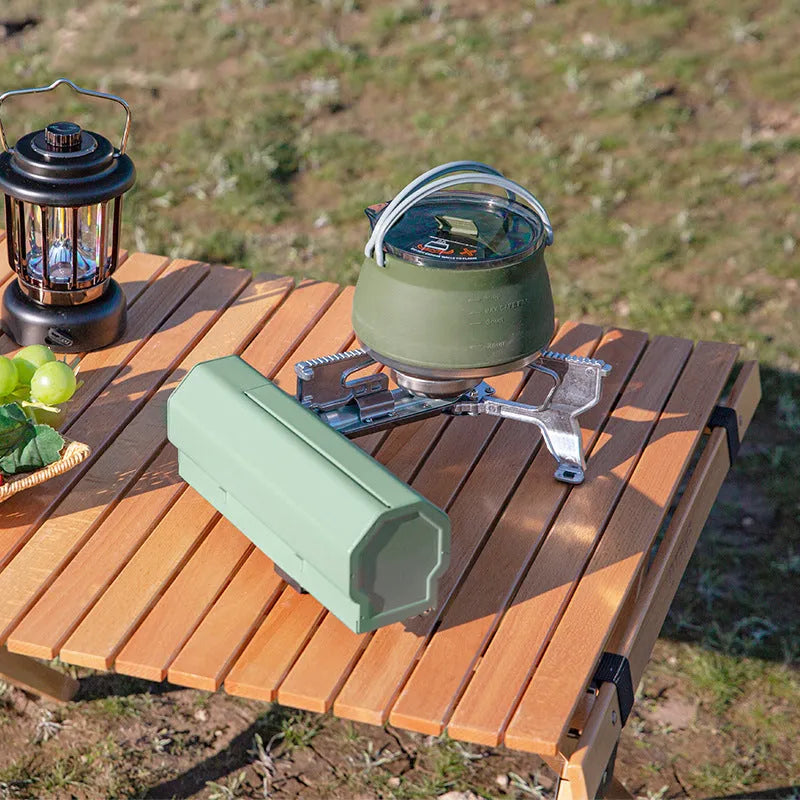 Green portable folding camping gas stove shown open for cooking and folded with its carry bag.