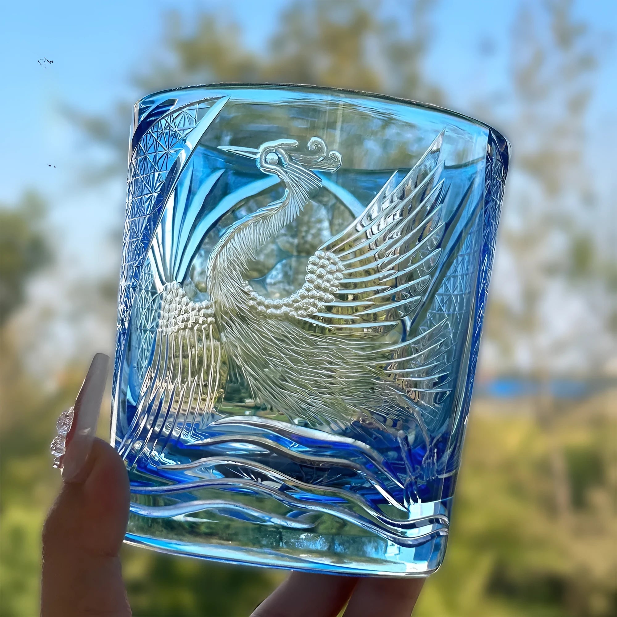 Hand-carved sky blue crystal whiskey shot glass on a wooden surface, 90x100mm size