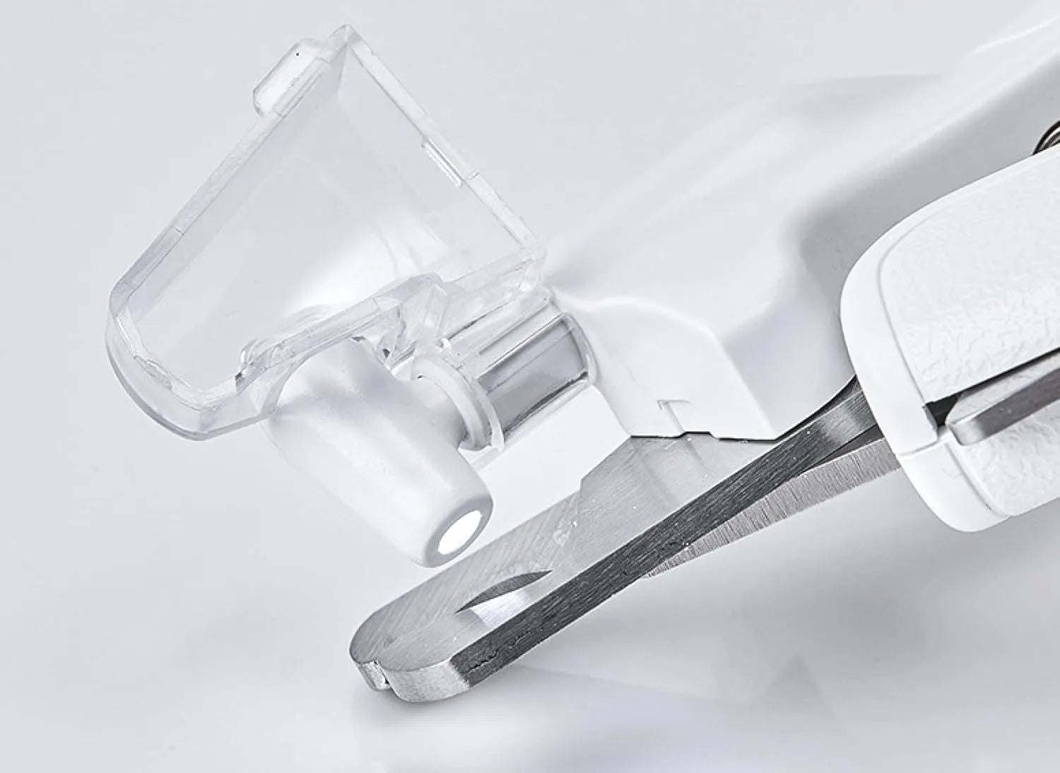 White pet nail clippers with LED light, transparent guard, and a nail file on a table