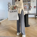 Women's high-waist knitted wide-leg trousers in cream white, showing straight-leg cut and drooping hem.