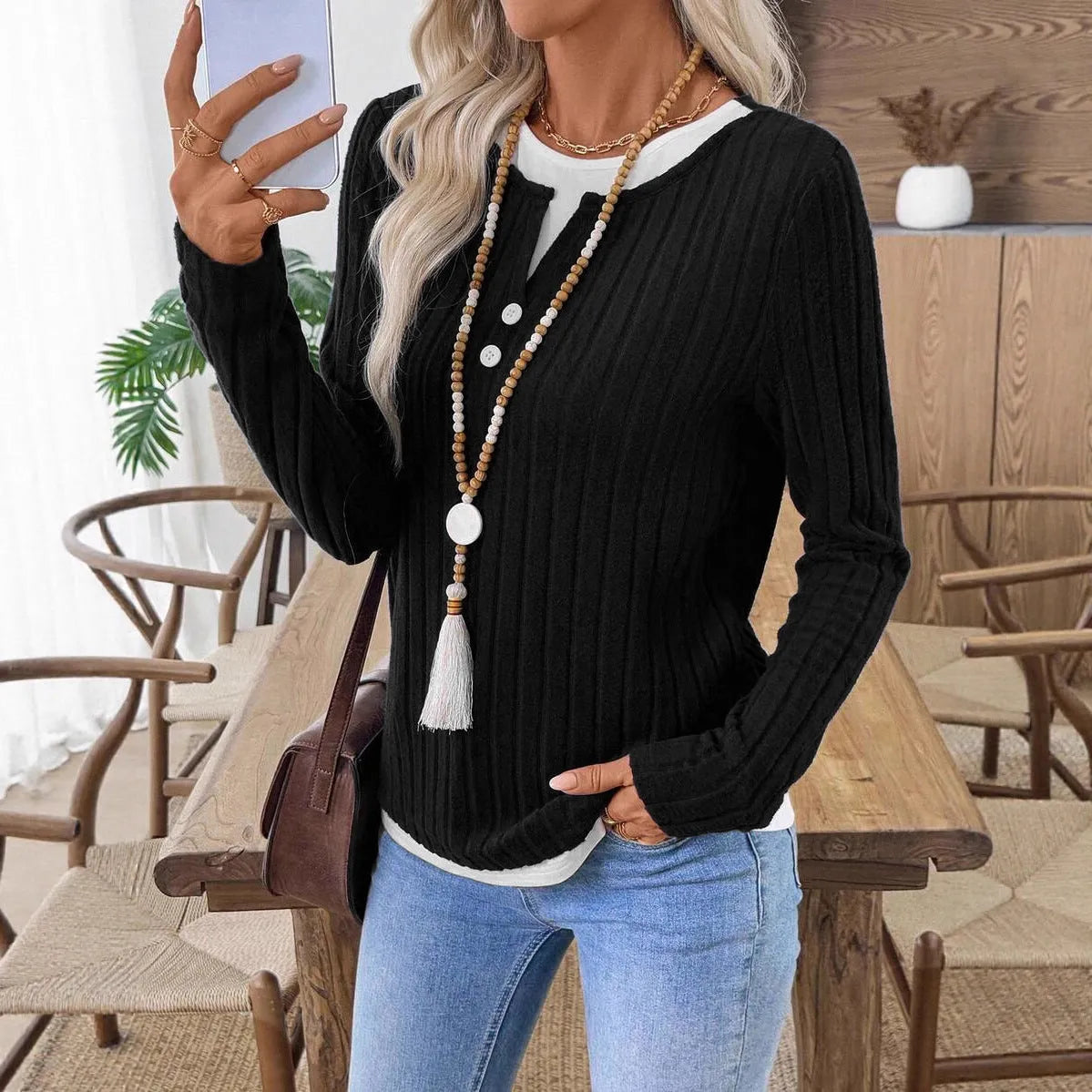 Women's black fake two-piece pullover sweater with a round neck and button front, showing concave stripe texture.