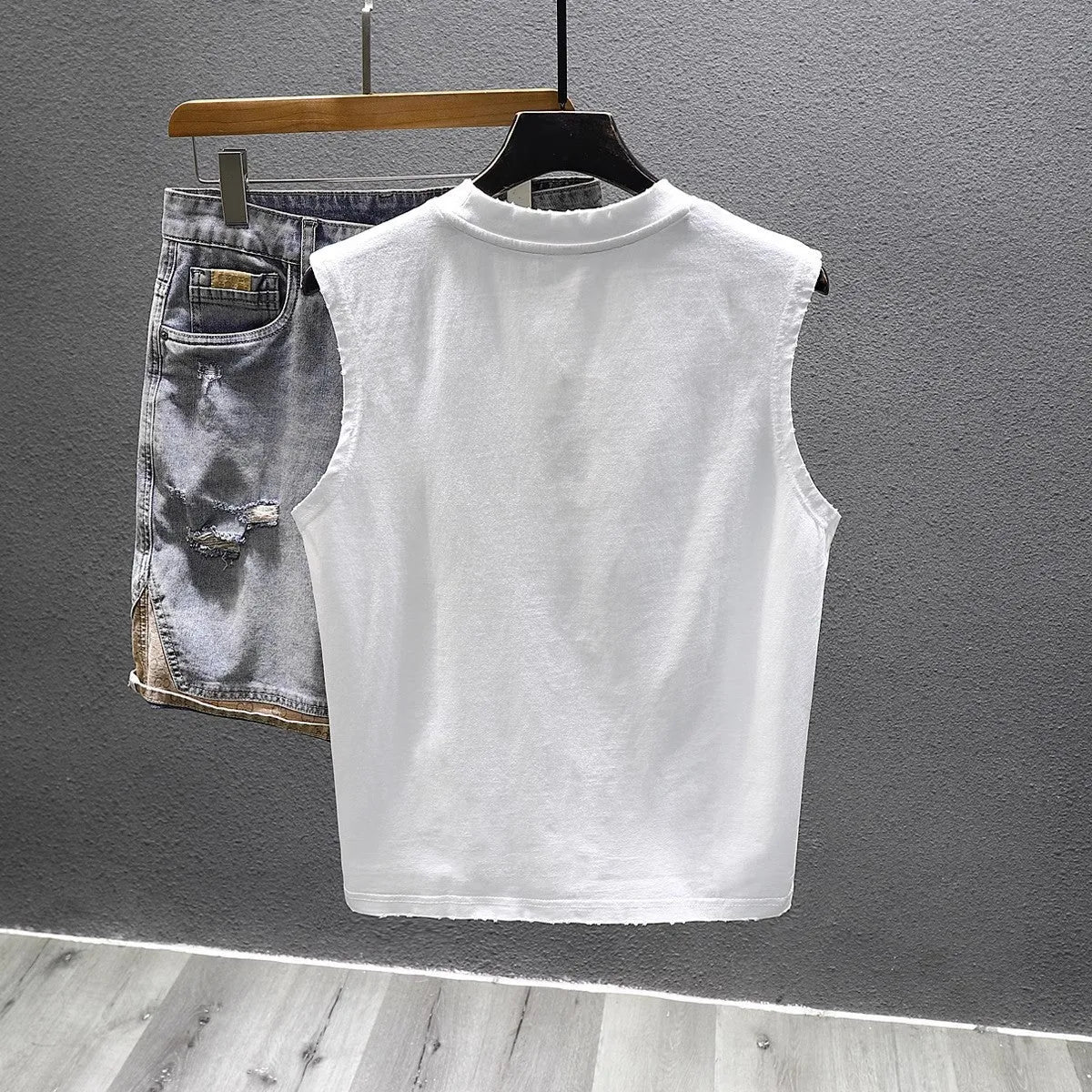 A solid colour loose cotton sleeveless t-shirt on a hanger, shown in white and black.