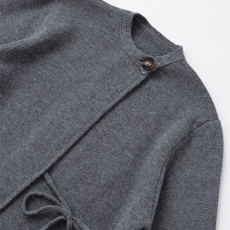 Women's long gray knitted coat with slit sleeves and pockets on display