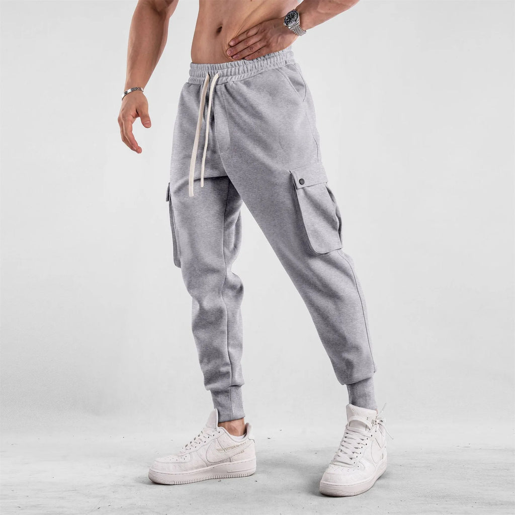 Men's loose-fit ankle-tied cotton sports trousers in solid colour with multi-pocket design