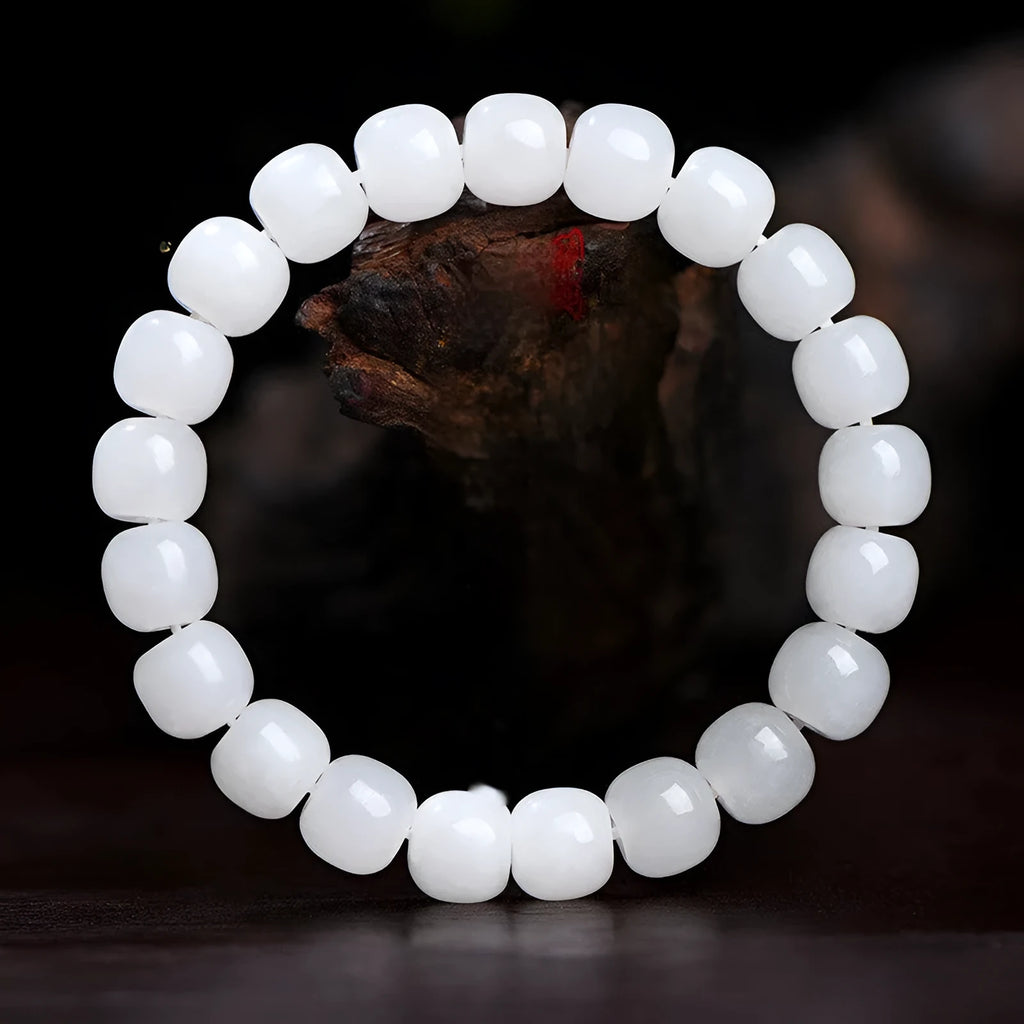 White Hetian jade barrel bead bracelet on a wrist, showing the smooth stone beads and unisex casual design.