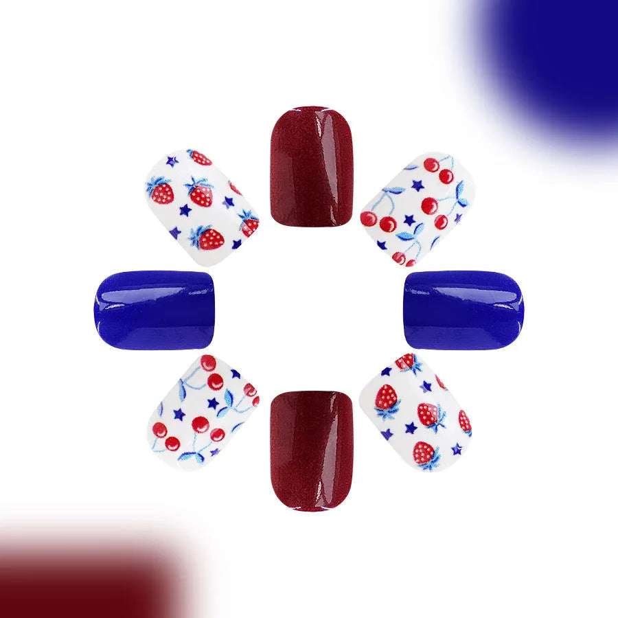 Short glossy false nails with strawberry and cherry patterns in red and blue colour combinations