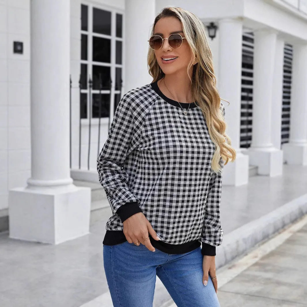 Black long sleeve pullover sweater with plaid stripes and printed pattern on a mannequin.