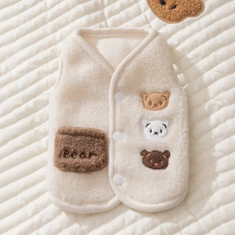 Brown fleece dog coat with bear embroidery and side-button closure on a small dog