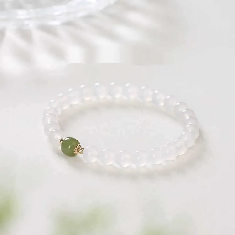Handmade white agate and crystal bracelet with red cinnabar inlay and text charm.