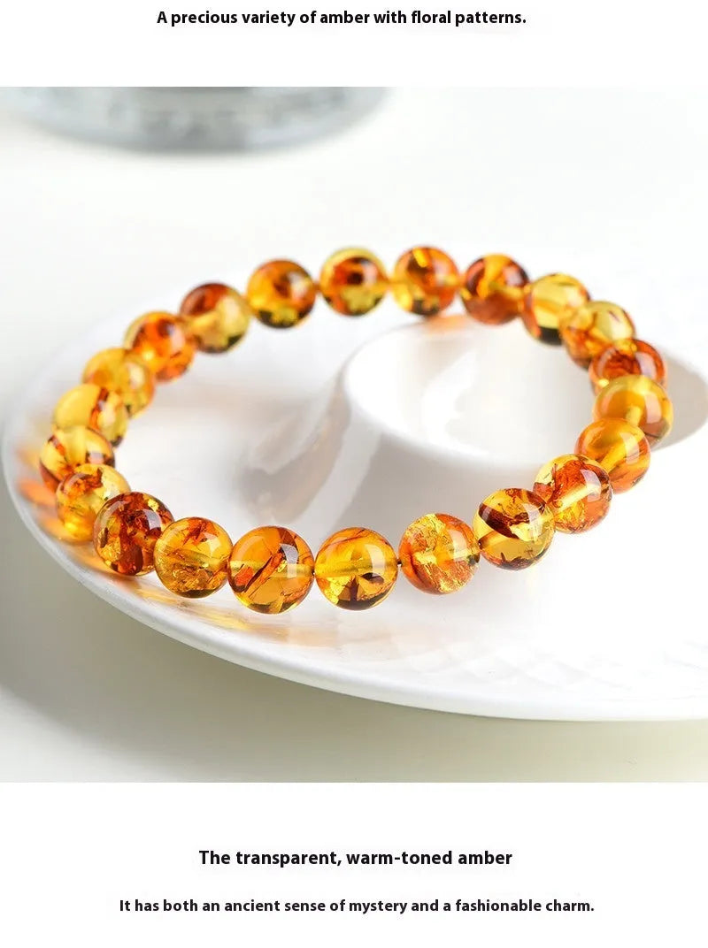 Natural yellow piebald amber bracelet with geometric beads on wrist.