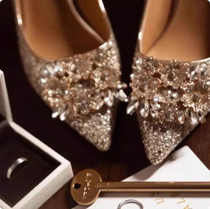 Champagne-coloured women's bridal shoes with rhinestone details, pointed toe, and a fine heel.