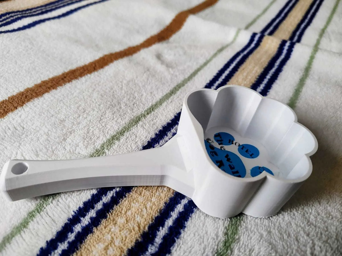 PLA cat paw pet food scoop in white and blue colour on surface
