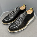 Men's black low-top sneakers with an embossed pattern and white laces.