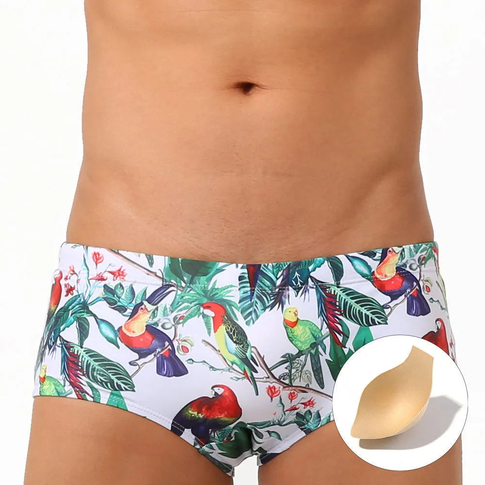 Men's navy blue swimming trunks with colourful flower and bird print pattern.