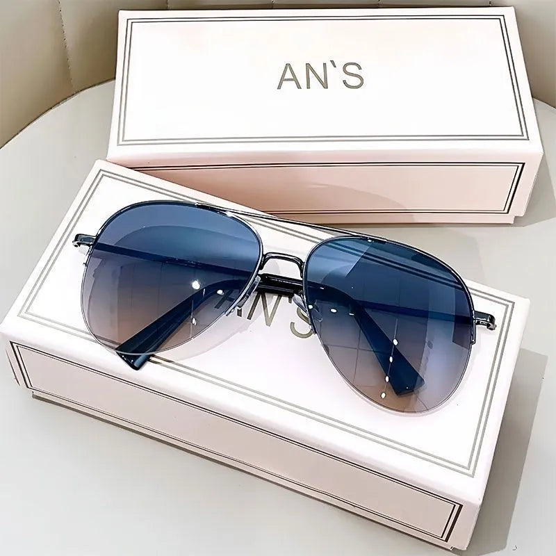 Aviator-style sunglasses with a metal frame and tinted resin lens, shown in a gold frame variant.