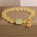 Women's yellow citrine crystal bracelet with sparkling rhinestone details on wrist.
