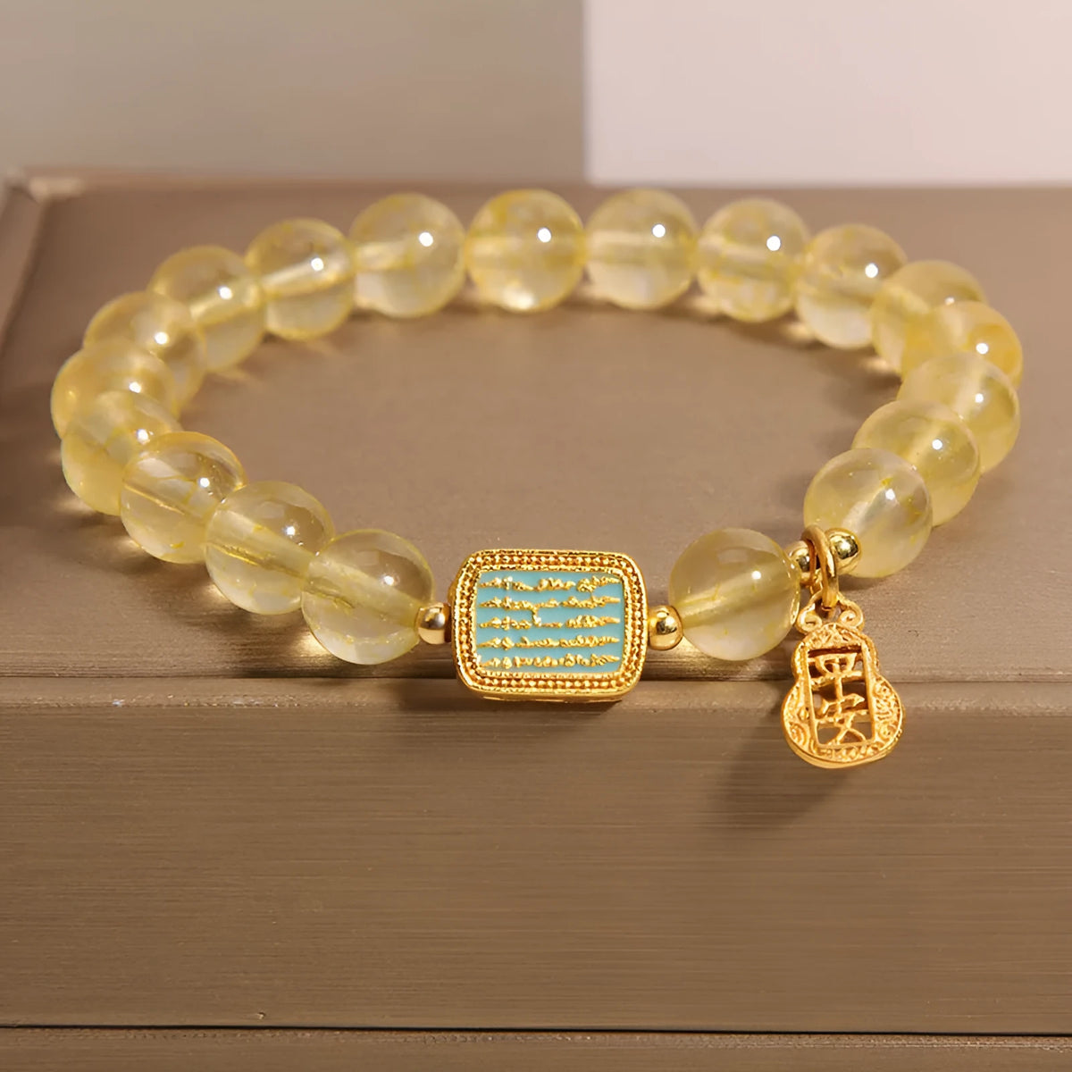 Women's yellow citrine crystal bracelet with sparkling rhinestone details on wrist.