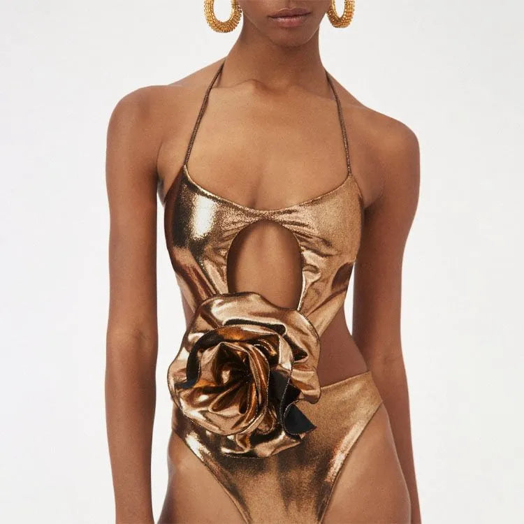 Gold coloured one-piece swimsuit with a halter neck and hollow-out design on a mannequin.