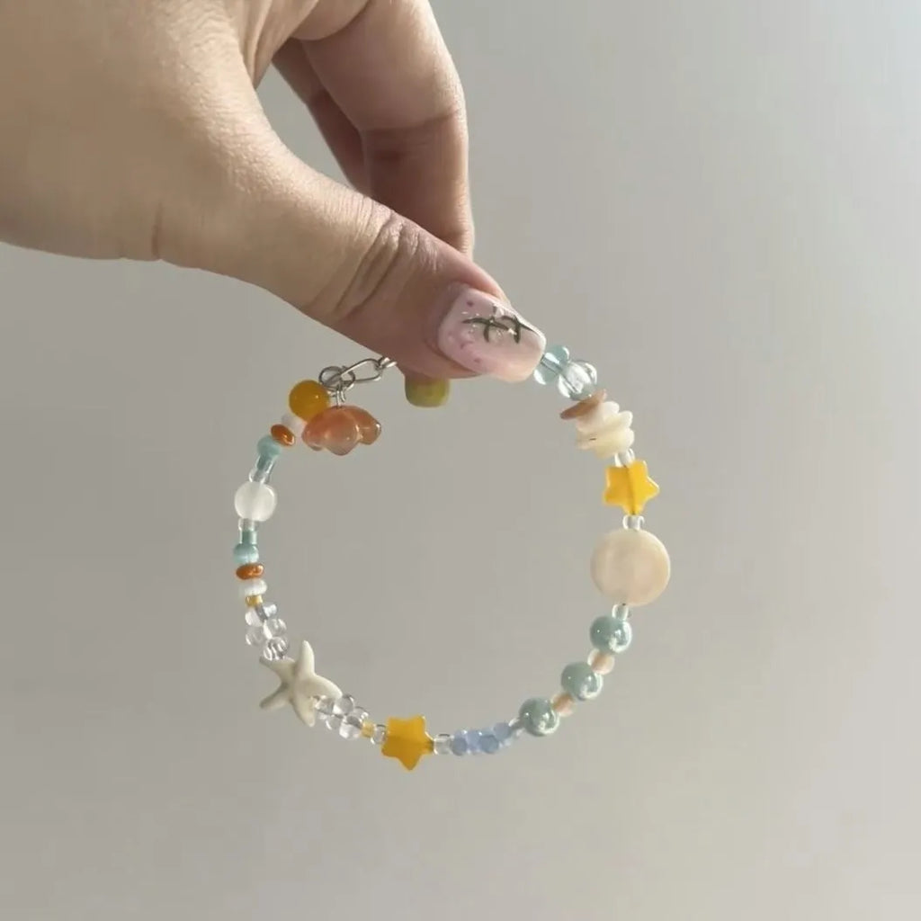 Orange diamond-shaped women's bracelet with round elements, made from mixed materials for summer seaside style.