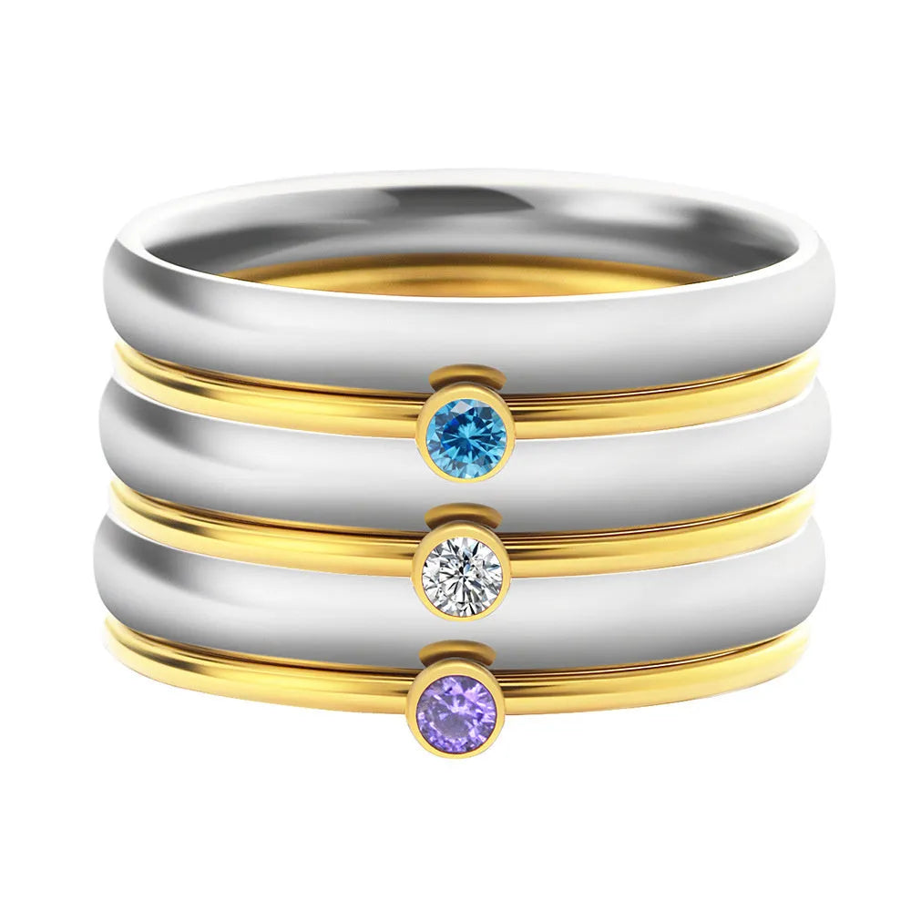 Gold tone titanium steel ring with a blue December birthstone and engraved geometric band.
