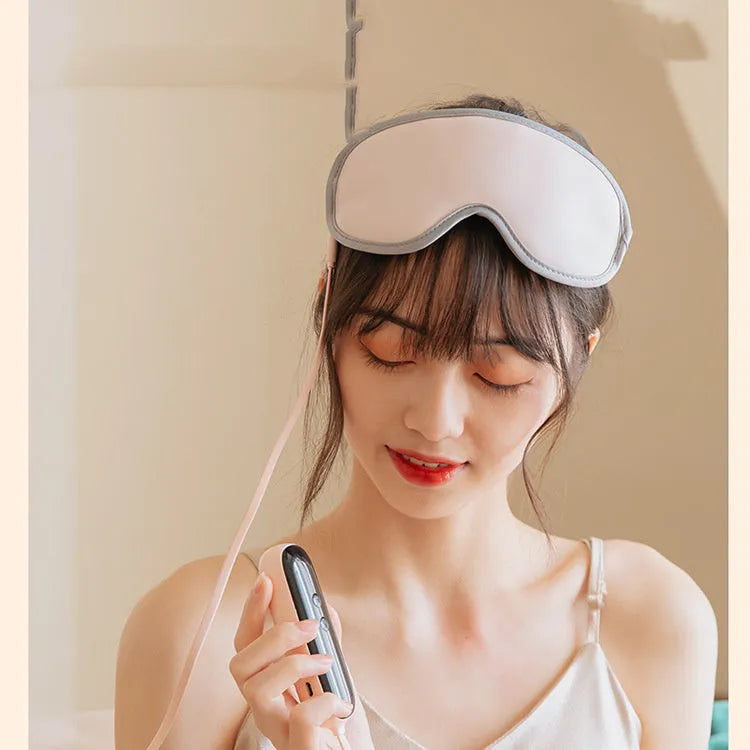 Green portable USB eye spa mask showing suede shell and super fibre interior on a desk.