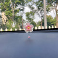 Small blue plastic swing-shaped car dashboard decoration.