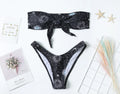 Black bikini print one-piece swimsuit with backless, split tube top design for women.