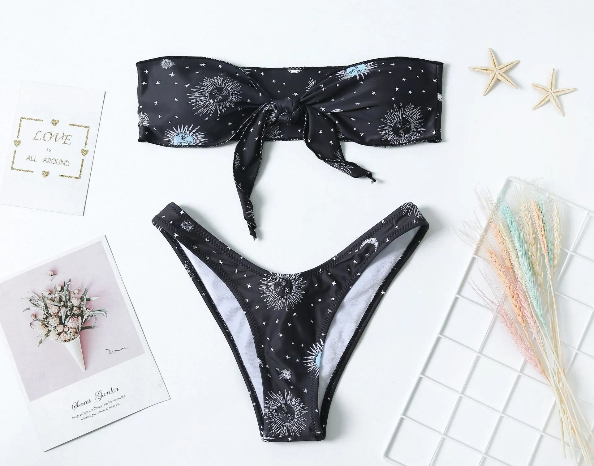 Black bikini print one-piece swimsuit with backless, split tube top design for women.