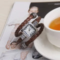 Snake bracelet quartz watch with leather strap and alloy buckle on a black background