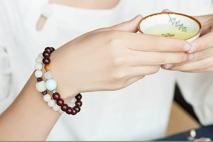 Natural white jade Bodhi bracelet with transfer beads on a neutral background