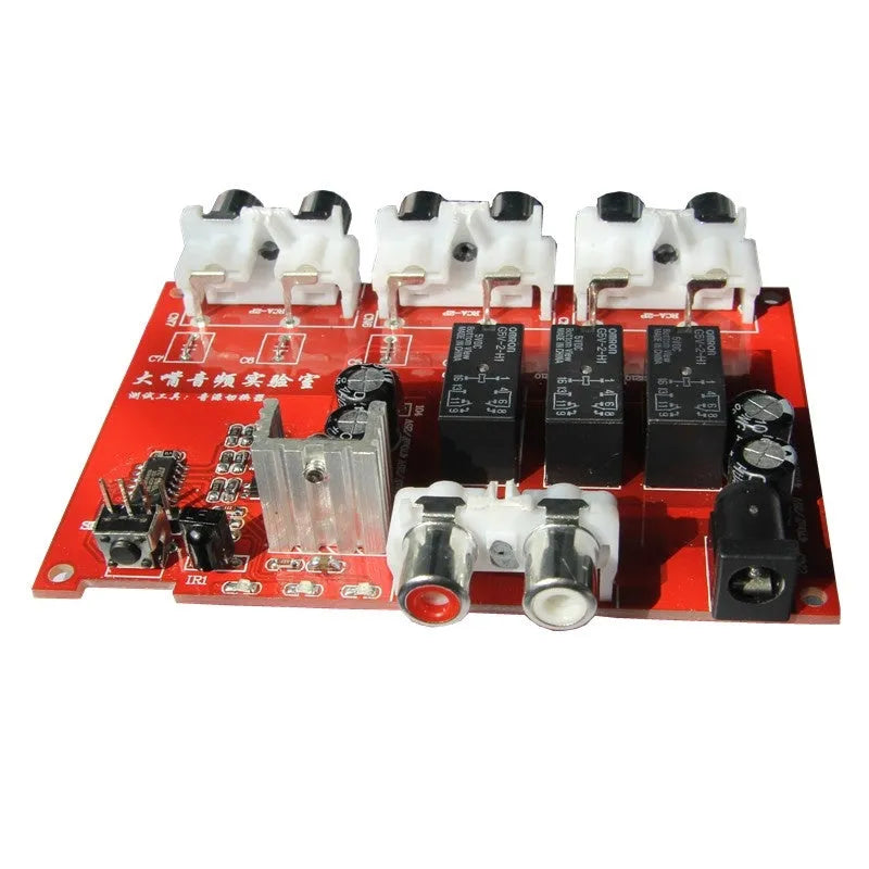 Silver aluminium audio source switch unit with front-panel buttons and infrared remote control.