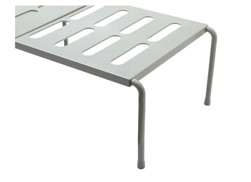 White telescopic plastic kitchen rack extended to 69cm height on kitchen countertop