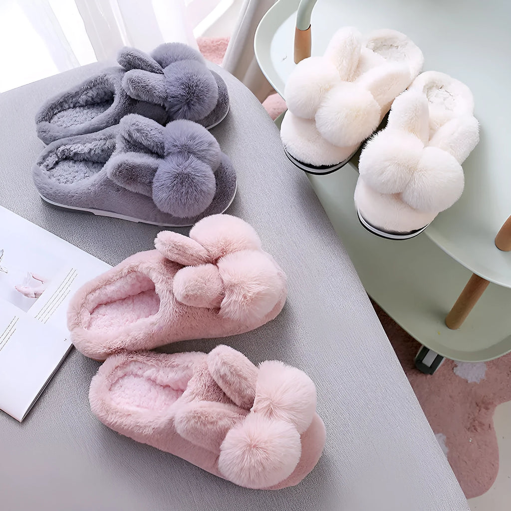 Women's fluffy high-top rabbit fur slippers in cream colour on a wooden floor.