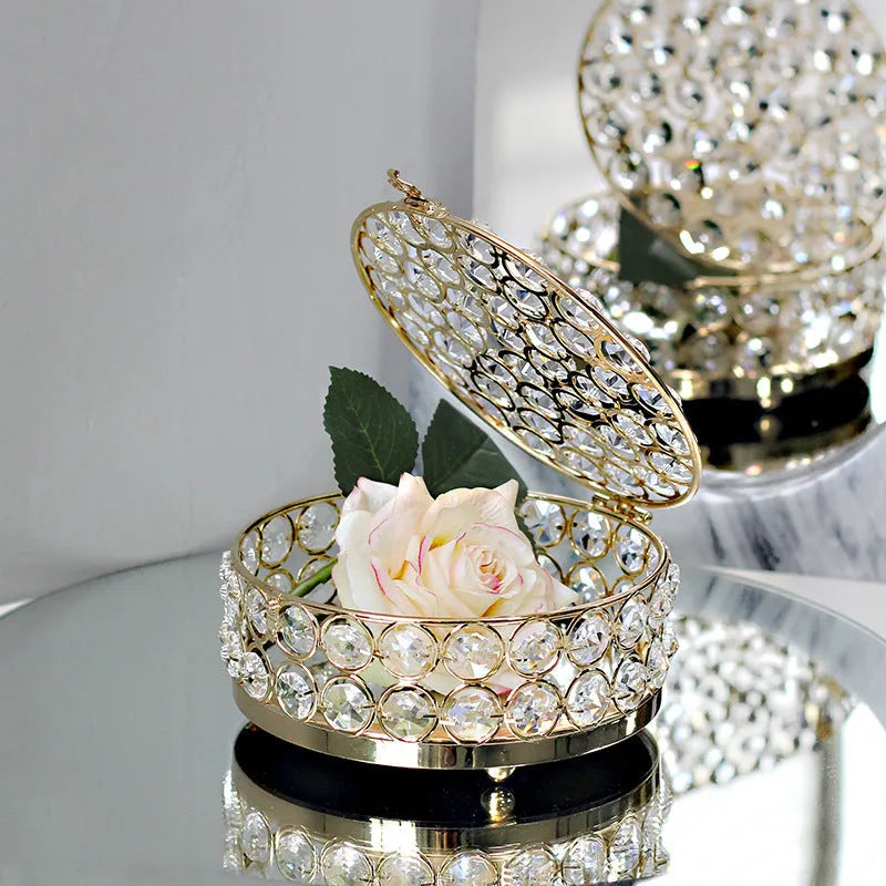French gold iron jewellery box with a clear crystal glass lid on a wooden surface.