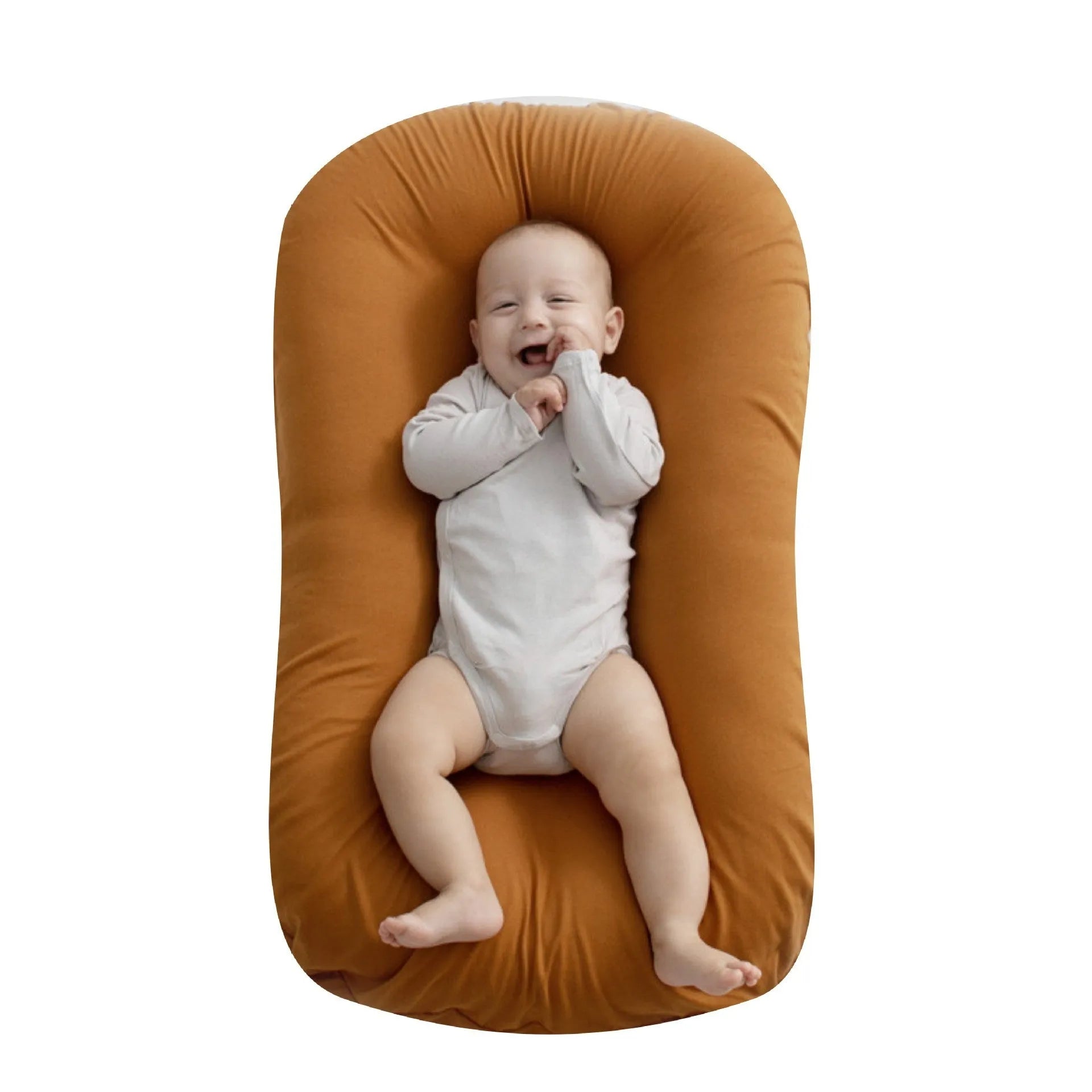Beige portable baby nest crib cot for newborns on a neutral background.
