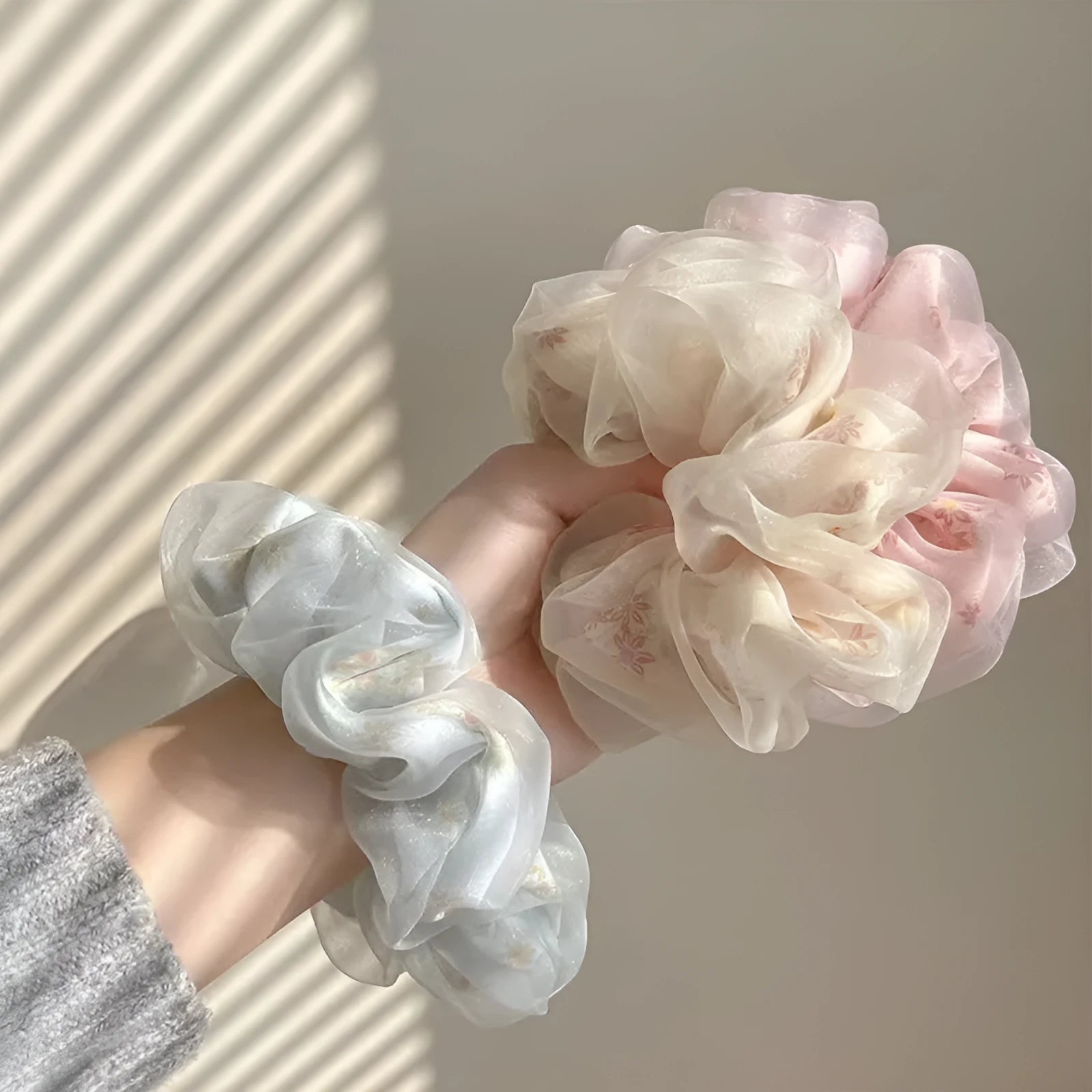 Mesh sense polyester large intestine hair band in milky white, pink, and light blue on a plain background
