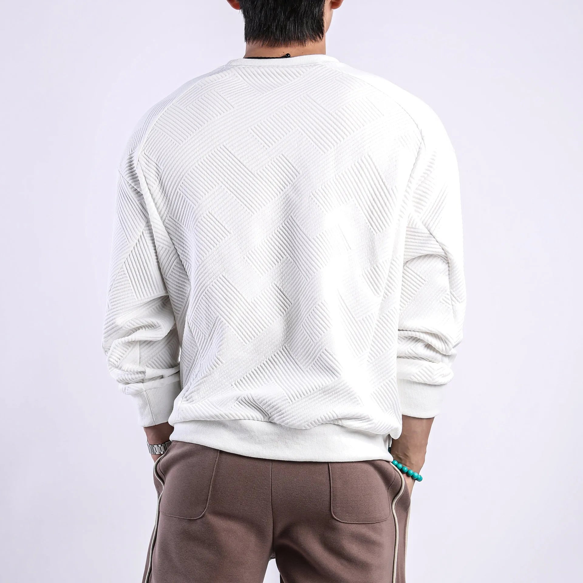 Man wearing a loose fit Army Green long sleeve twill jacquard pullover sweater.