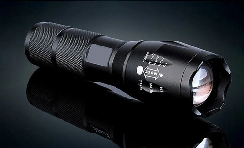 Black aluminium zoom flashlight with adjustable focus ring, shown next to an 18650 battery.