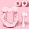 Purple, grey, white, and pink facial brush with coral fleece hair band and multiple brush heads