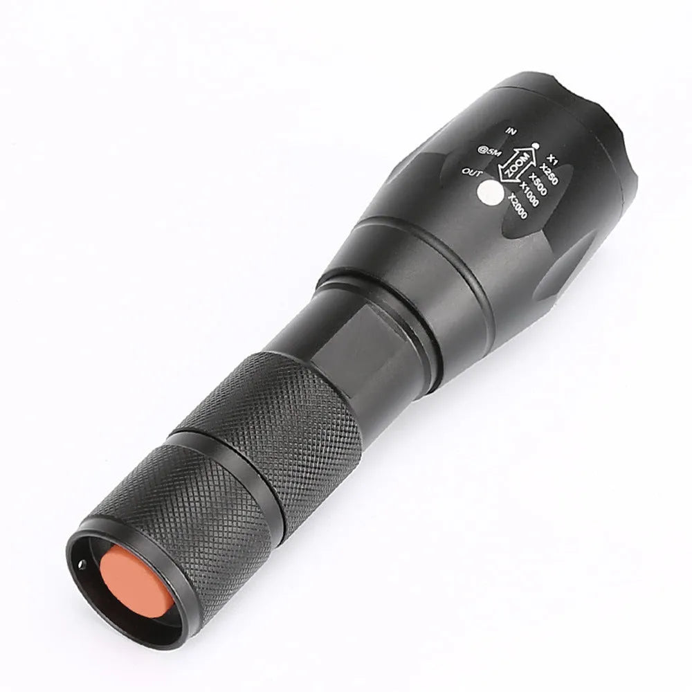 Black aluminium zoom flashlight with adjustable focus ring, shown next to an 18650 battery.