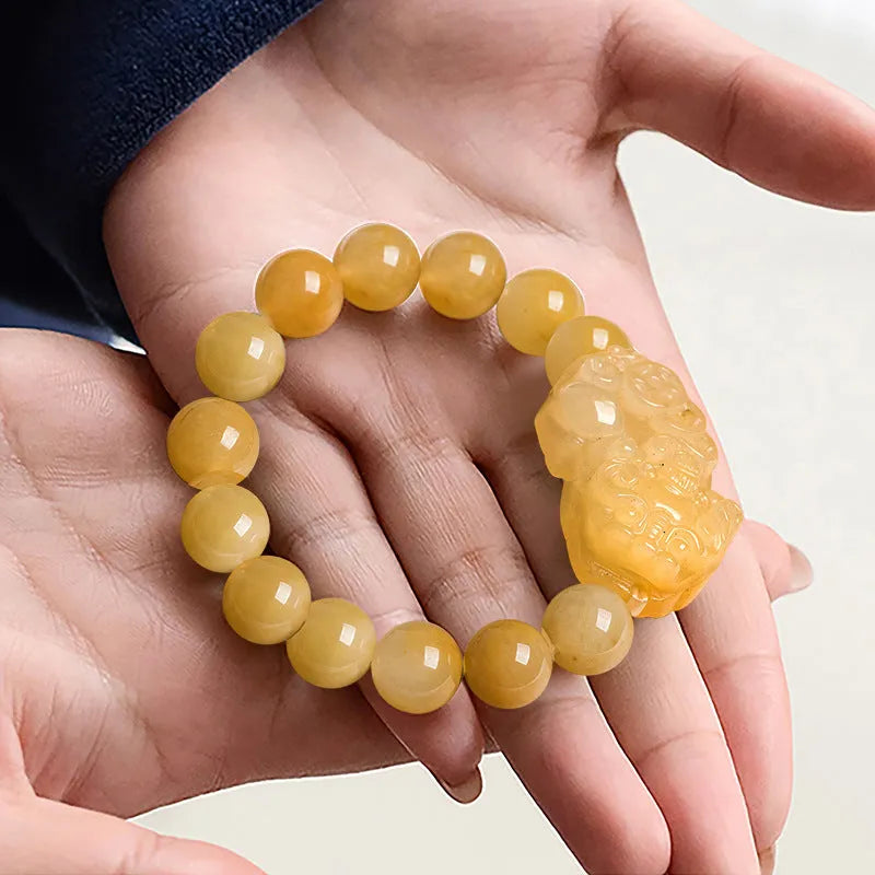 Hand-carved Golden Thread Jade money bracelet showing detailed coin design on round jade beads.