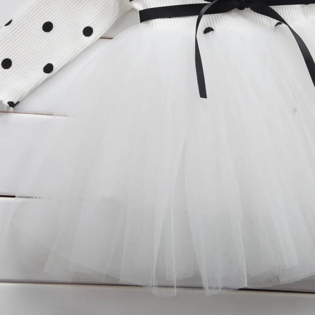 Baby girl in a long sleeve black lace tutu dress, suitable for christenings and parties.