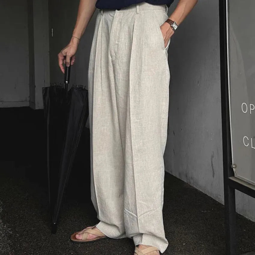 Men's light-weight wide-leg cotton linen trousers in apricot colour, showing loose fit and zip placket.