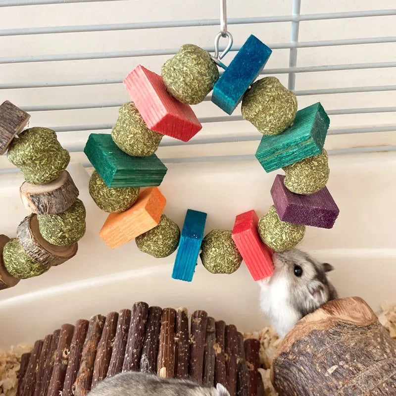 Hamster chew toy featuring an applewood rod with an attached woven straw ball ring.