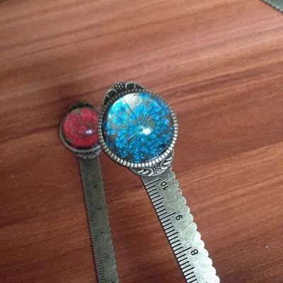 Handmade dried flower bookmark ruler with gypsophila, lace flowers, and clover, 12cm long on a book page.
